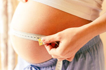 Measure belly pregnancy woman. Happy young pregnant woman with tape measuring belly. Concept maternity, pregnancy, childbirth.