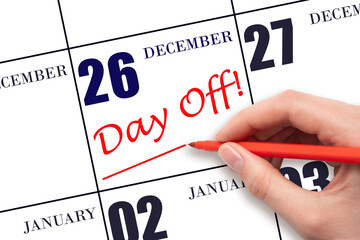 26th day of December. Hand writing text DAY OFF and drawing a line on calendar date 26 December. Vacation planning concept. Winter month, day of the year concept.