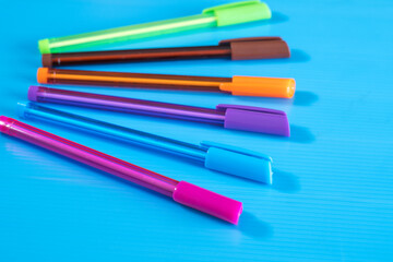 Color pens lying on blue background