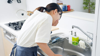 妊娠してつわりに苦しむ料理中の女性（家事・主婦・キッチン） © polkadot