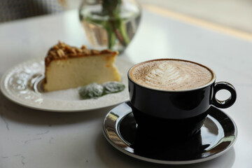 Cup of fresh coffee and dessert on table