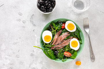 Nicoise french composed salad with canned tuna, anchovy, hard-boiled eggs, tomatoes, and black...