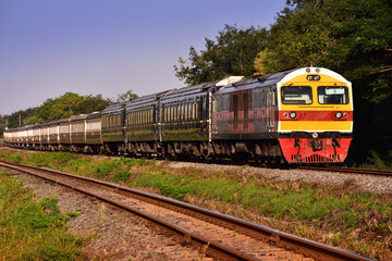 Fototapeta premium Passenger train by diesel locomotive on the railway in Thailand