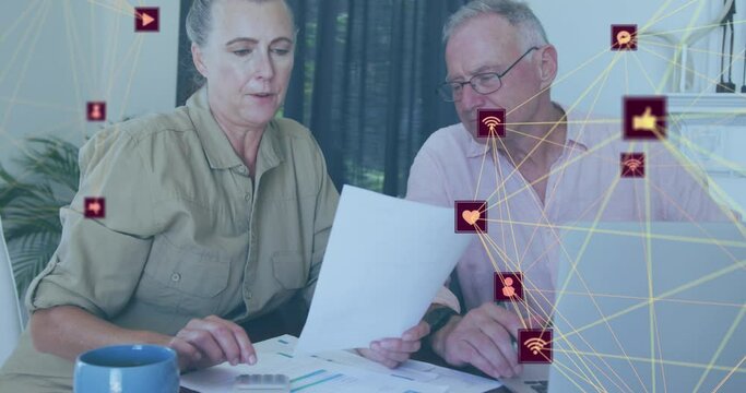 Animation of network of connections with social media icons over senior caucasian couple takling