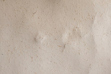 Selective focus shot of shaped adobe house wall.