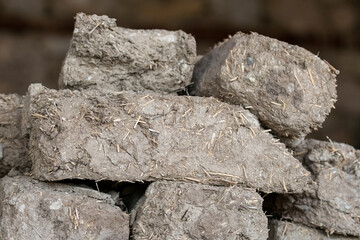 Selective focus shot of stacked adobe bricks after cutting and drying.