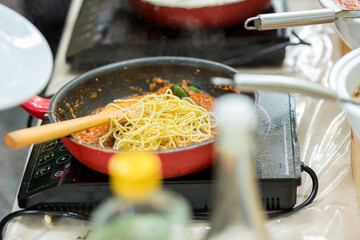 Cooking spaghetti concept. Pasta in the pan. Cooking Fresco Pasta. Italian cuisine, Cooked Italian spaghetti being put into hot bolognese sauce in the pan
