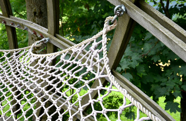 nets on the children's playground stretched between the wooden structure of the children's playground. suspended as a hammock or a lounger made of ropes. tied metal eyes or knots to the frame