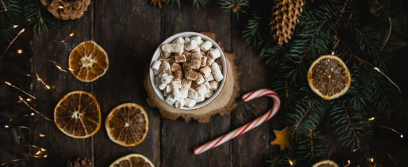 Christmas background candy cane branches Hot Chocolate Beverage dried orange slices on dark wooden background. Holiday card. Top view flat lay. Christmas or New Year composition. selective focus