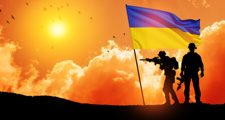 Flag of Ukraine with silhouette of soldiers against the sunrise or sunset. Concept - armed forces...