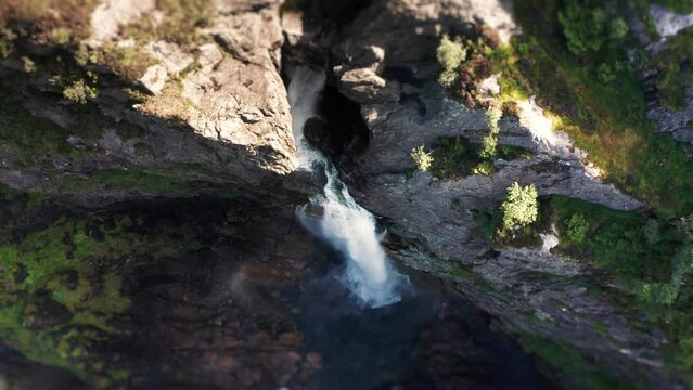 Aerial view of the waterfall cascading into a deep gorge. water dust rising high in the air. Slow-motion.