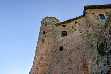 Fototapeta na wymiar Low-angle view of the medieval castle, characterized by three cylindrical towers, in the Langhe vineyard area, Unesco Site, Castiglione Falletto, Cuneo, Piedmont, Italy