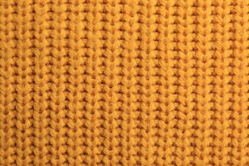 Beautiful orange knitted fabric as background, top view