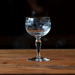 antique transparent glass wine glass on a black background. crystal glass with engraving. glass close-up