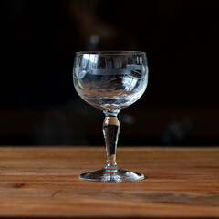 antique transparent glass wine glass on a black background. crystal glass with engraving. glass close-up
