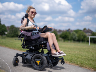 Fototapeta na wymiar Woman in electric wheelchair going on walk