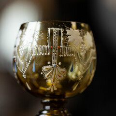 orange glass goblet of unusual shape in a luxurious interior. orange goblet close-up. bohemian glass closeup