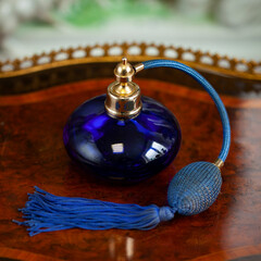 Vintage bottle of perfume in luxyry interior. vintage round blue bottle of perfume in luxyry...