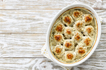 Cheesy creamy meatballs in baking dish. Top view, copy space, flat lay.