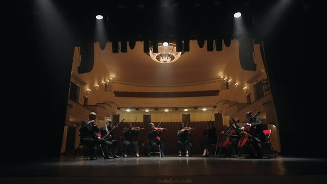 classic music orchestra is playing music on scene of old opera house, beautiful concert hall