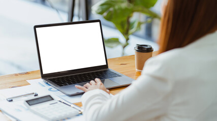 Close-up back view of a business woman working in the office typing, looking at the screen. office worker using a notebook computer.