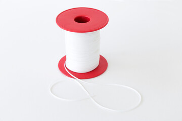 spool of white nylon braid for shoes, on a white background