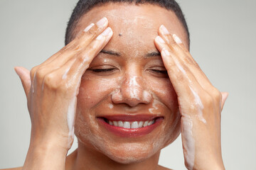Close-up of smiling woman washing face - obrazy, fototapety, plakaty