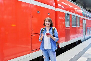 Woman passenger waiting on railway platform inside station