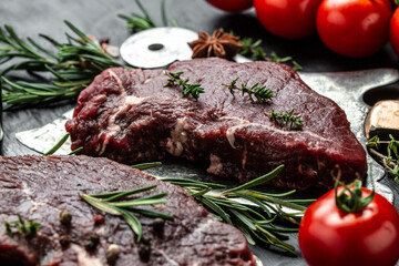 Pieces of cooked rump steak with spices served on grill pan. Steak of marbled beef black Angus. Raw beef ramp steak, top view