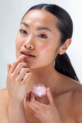 Studio portrait of woman applying lip balm