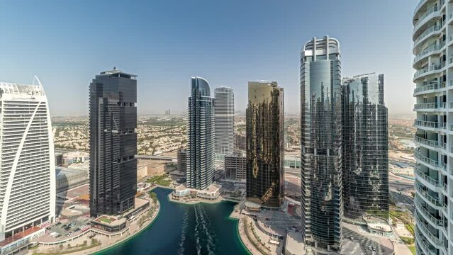Panorama showing tall residential buildings at JLT district aerial timelapse, part of the Dubai multi commodities centre mixed-use district. Villa houses on a background
