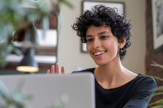 Young woman having video call on laptop in office