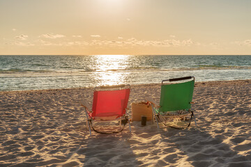 Beach chairs at sunset in tropical beach with accessory. Summer vacation and tropical beach concept. - obrazy, fototapety, plakaty