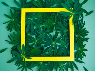 composition with green leaves and empty yellow frame. Creative layout of nature. copy space