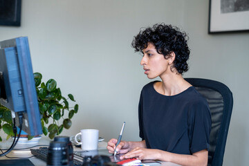 Young female graphic designer working in office