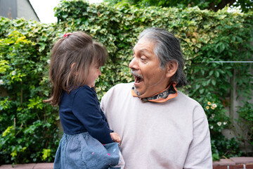 Smiling senior man with granddaughter outdoors