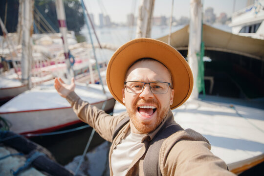 Happy man driver in hat takes selfie photo background yacht summer day, concept rent for travel boat