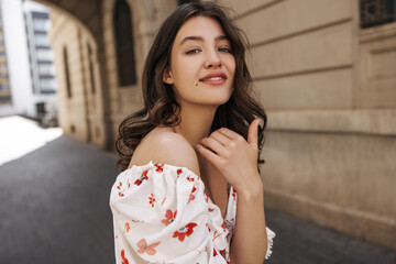 Attractive young caucasian woman posing looking at camera, walking in fresh air during day....