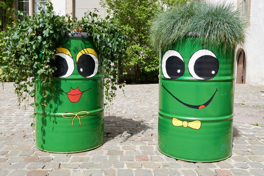 pot de fleurs d&eacute;coratif original fait dans un bidon de m&eacute;tal avec une expression humaine dr&ocirc;le peinte dan sun jardin au soleil en &eacute;t&eacute; 