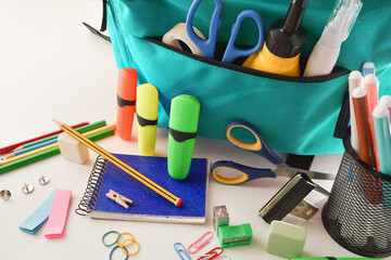 Fototapeta School supplies and blue backpack on white table obraz