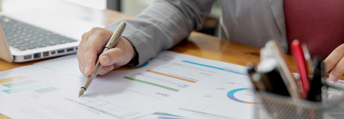 Asian businesswomen are analyzing graphs, Financial statistics and calculating corporate returns in private offices, Market research reports and income statistics, Financial and Accounting concept.