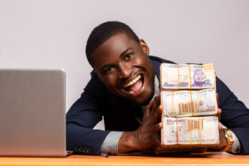 african businessman with a bundle of cash looks excited