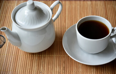 Tea couple with Viennese waffles on a mat. Tea party with waffles. A porcelain cup and saucer on a mat.