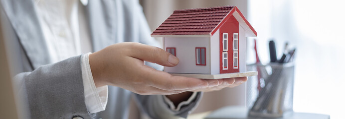 Sales manager or salesperson holds a demo house and has a home purchase contract with keys to...