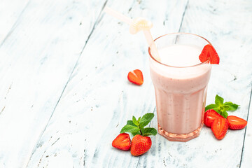 Strawberry smoothie or milkshake with berries and yogurt in glass jar on white concrete background. Vegetarian healthy drink. place for text, top view