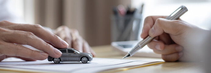 Dealer or manager gives the car to the customers who sign the car purchase documents with insurance, Signing a contract to buy a car that is legal, Document signing and credit approval Concept.