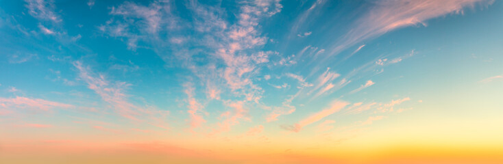Gentle romantic pink cirrus clouds in the dawn sky. Delicate mood of the Sunrise Sundown Sunset sky. Panorama.