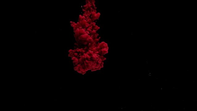 Slow motion of red fluid color flow into dark and water background , colorful art content