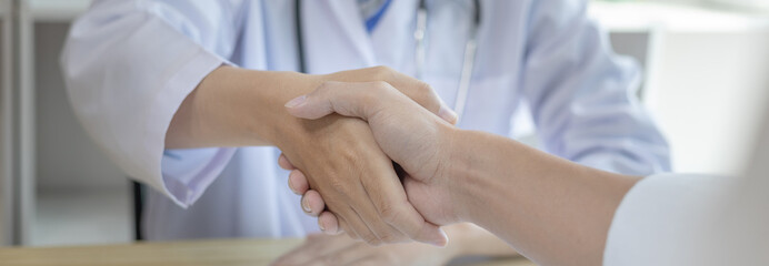 Doctor shake hands to congratulate the patient who came to treat the sick and recovered normally. Congratulations between doctor and patient, Medical treatment and health check.