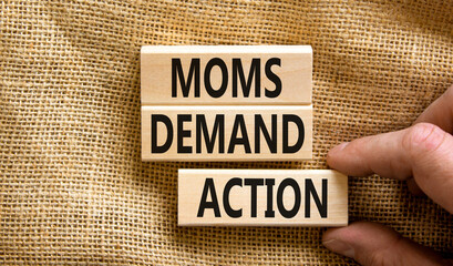 Moms demand action symbol. Concept words Moms demand action on wooden blocks on a beautiful canvas...